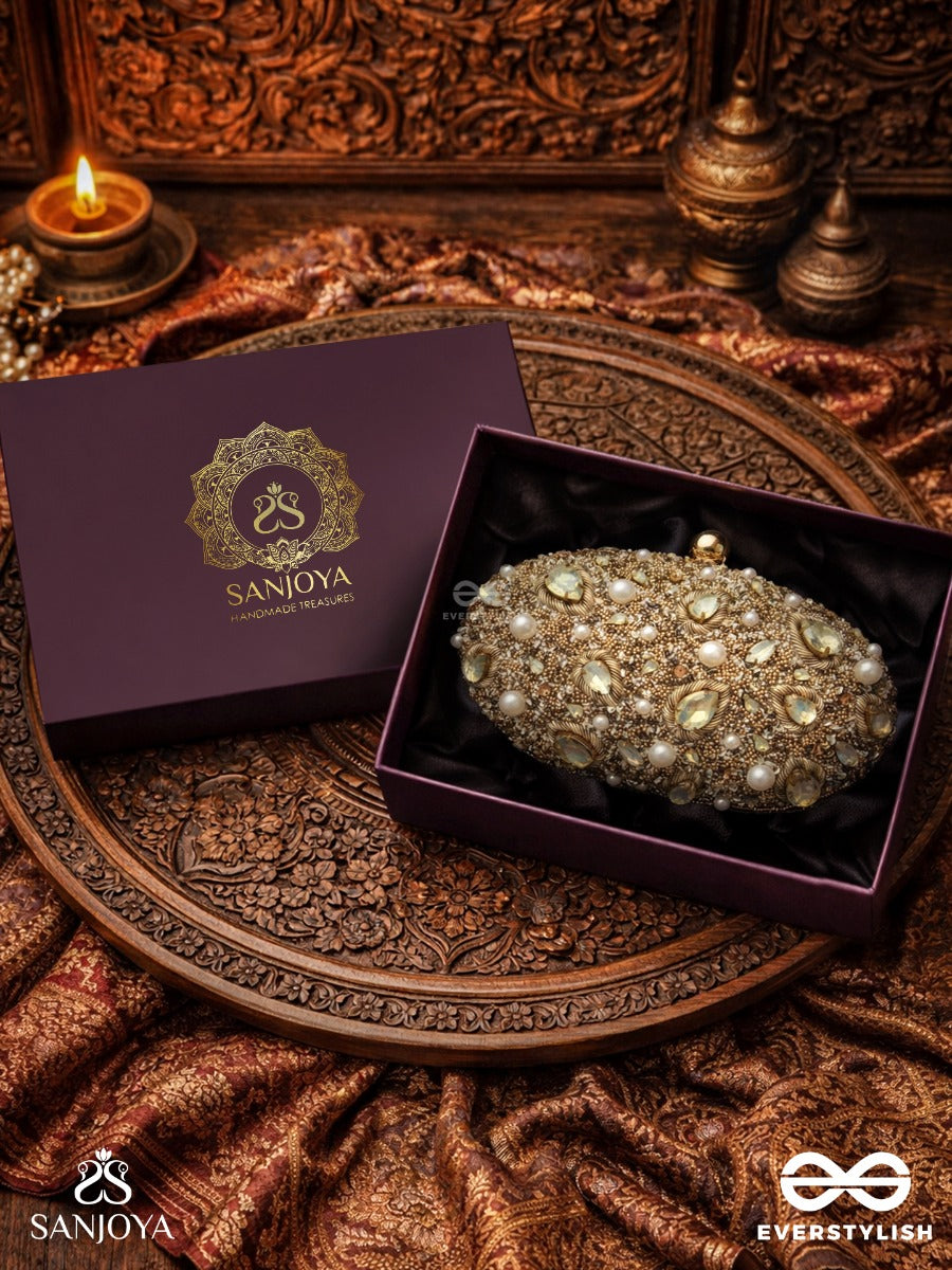 Chandraaya – Polished Oval Golden Bronze Silk Clutch With Intricate Jewel Stone Embellishment And Golden Metal Frame