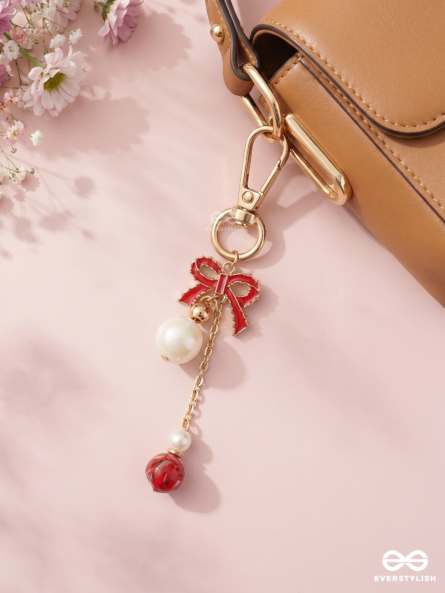 Bowtique – Satin Bow Bag Charm With Ruby Crystal Drop