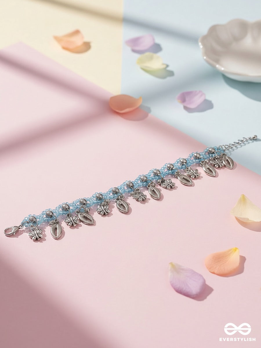 Coastal Jingle – Sky Blue Thread Anklet (Single) With Cowrie Shells And Floral Charms