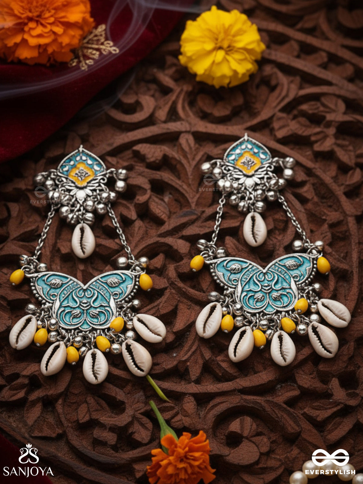 Shankha Pushpa- Conch Blossom-Oxidized Earrings With Pastel-Hued Metalwork, Embellished With Delicate Cowrie Shells, Yellow Beads And Ghungroo