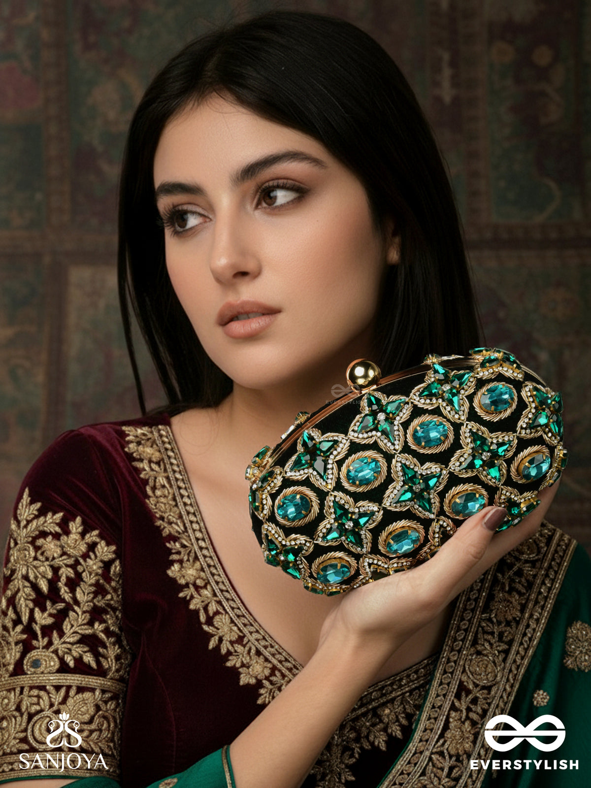 Neelzara – Oval Dark Green Velvet Clutch With Intricate Stone And Zardozi Work And Golden Metal Frame