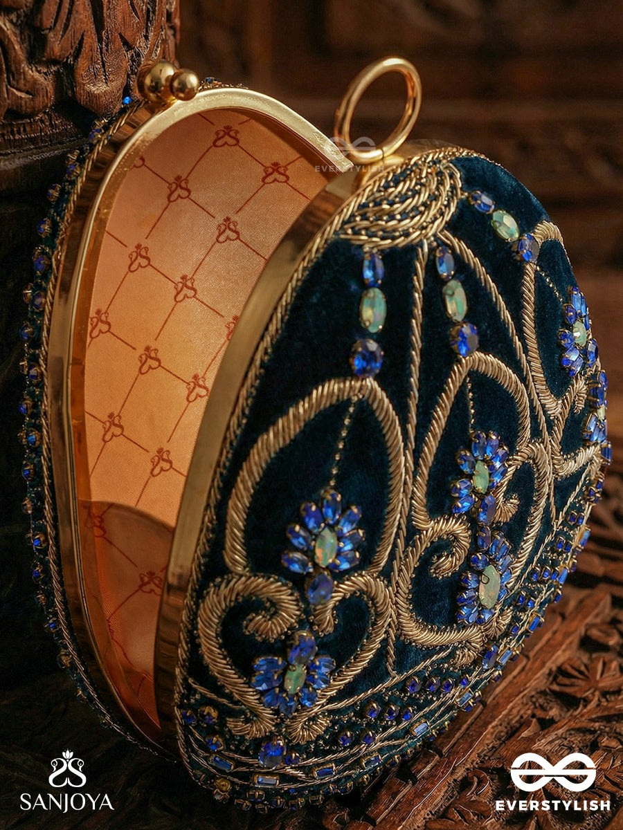 Sitaraa – Polished Oval Royal Blue Velvet Clutch With Stone-Accented Handwork And Golden Metal Frame