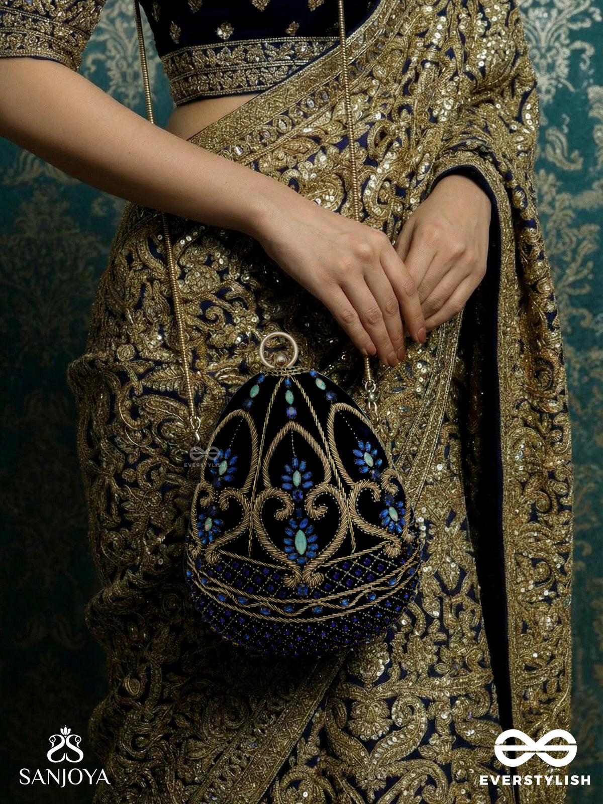 Sitaraa – Polished Oval Royal Blue Velvet Clutch With Stone-Accented Handwork And Golden Metal Frame