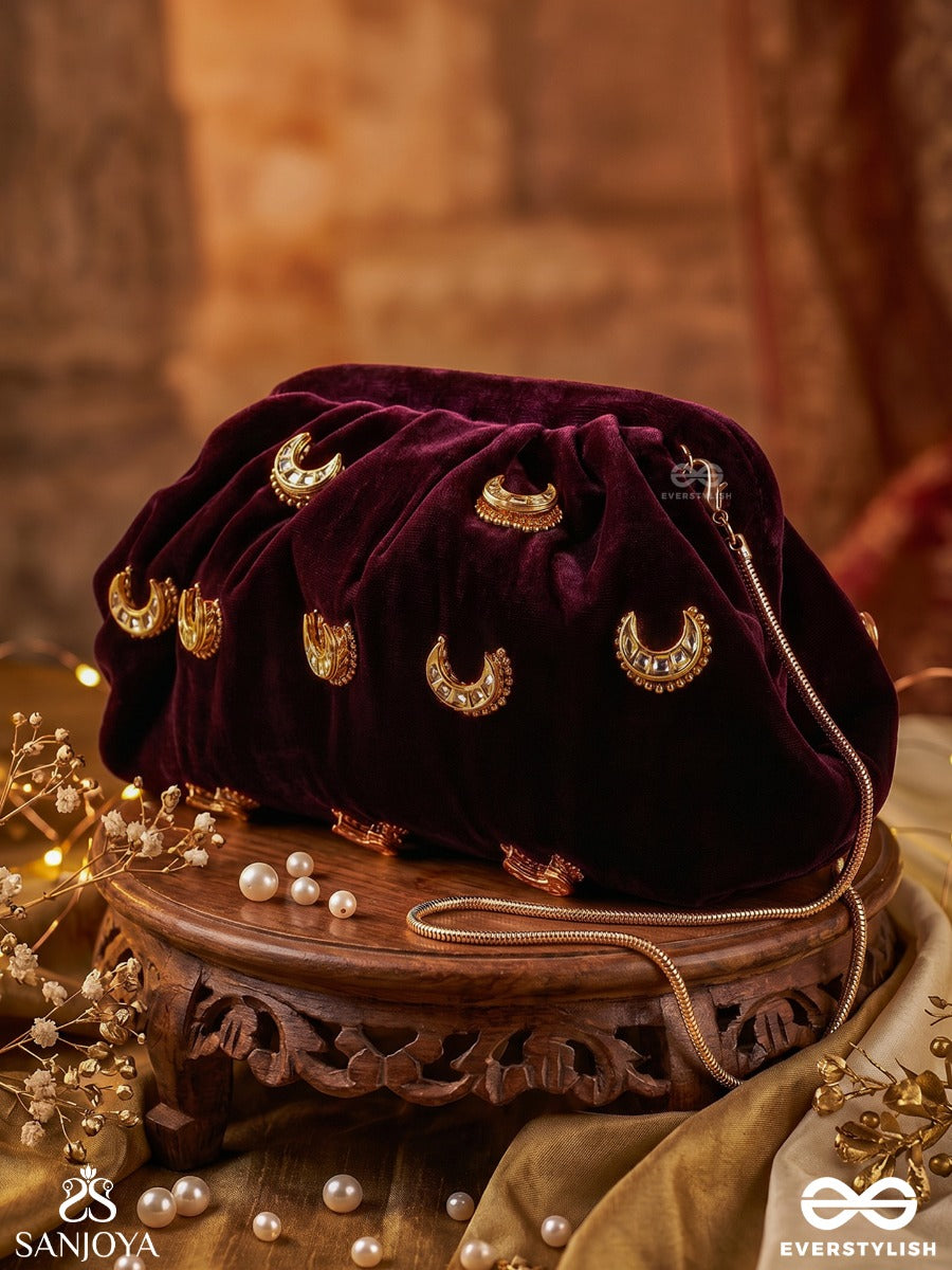 Ayshaan – Oval Burgundy Velvet Clutch With Kundan Moon Motifs, Delicate Pearlwork And Draped Silhouette