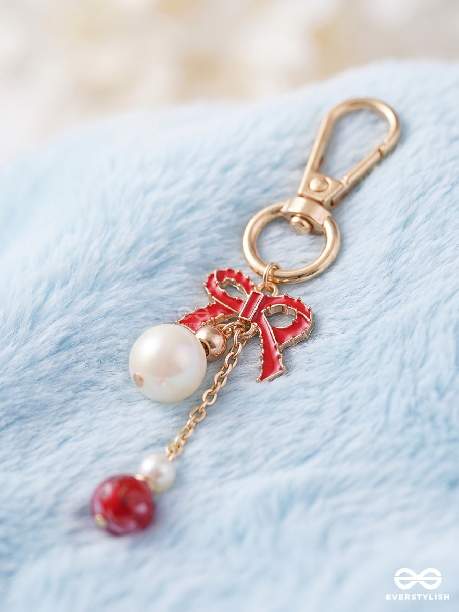 Bowtique – Satin Bow Bag Charm With Ruby Crystal Drop