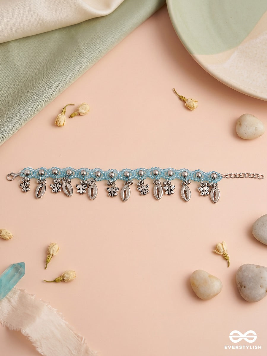 Coastal Jingle – Sky Blue Thread Anklet (Single) With Cowrie Shells And Floral Charms