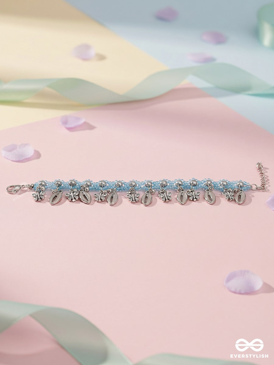 Coastal Jingle – Sky Blue Thread Anklet (Single) With Cowrie Shells And Floral Charms