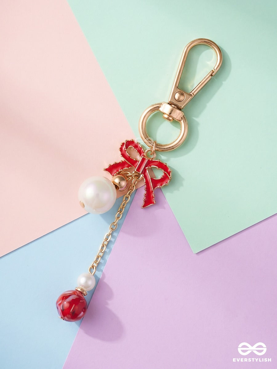 Bowtique – Satin Bow Bag Charm With Ruby Crystal Drop