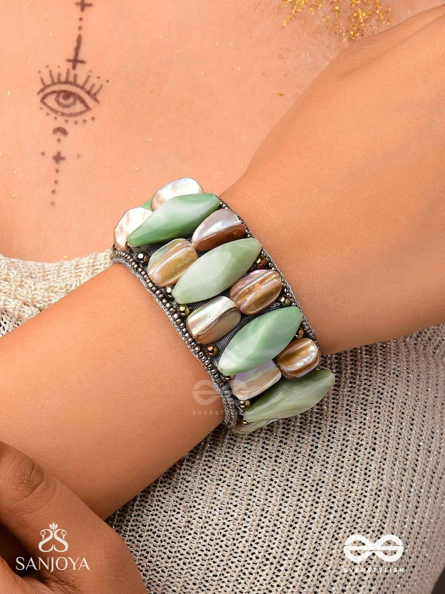 Shuktimala- Shell Band-Expandable Bracelet Crafted From Shell Beads, Combining Turquoise And Beige-Brown Tones With A Brassy Finish.
