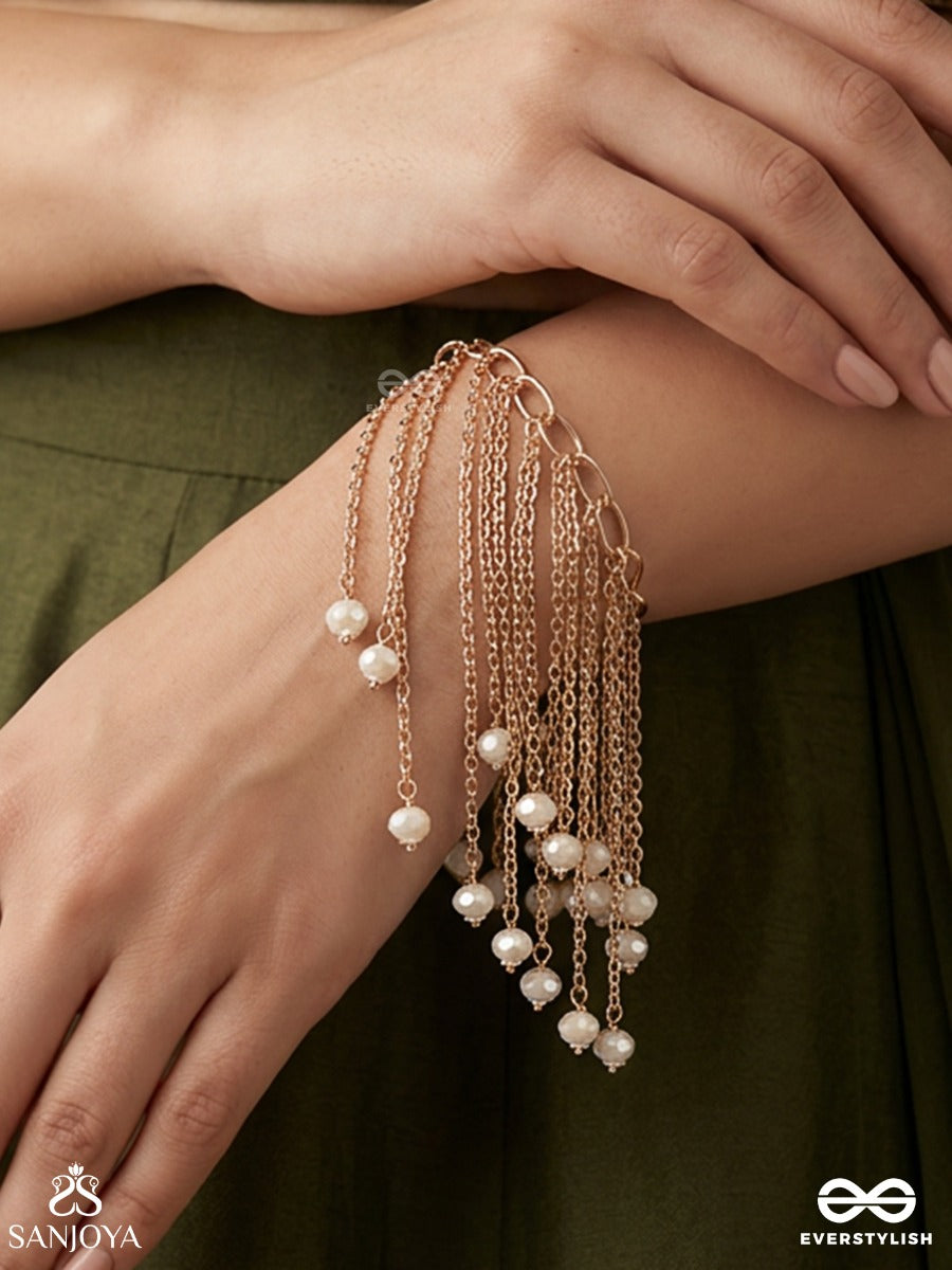 Sajlehra – Adorned Wave – Elegant Hanging Bracelet With Multi-Strand Gold-Tone Chains, Pearl-Like Drop Accents And A Flowing Tassel Finish