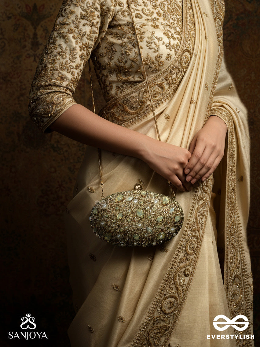 Chandraaya – Polished Oval Golden Bronze Silk Clutch With Intricate Jewel Stone Embellishment And Golden Metal Frame